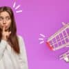woman holding finger in front of her lips and shopping cart
